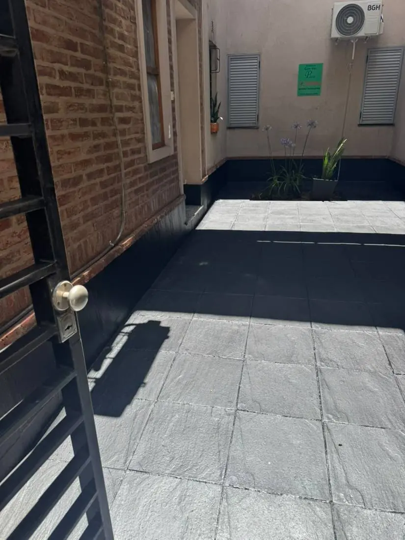 Patio con piso pintado en gris y zócalos negros